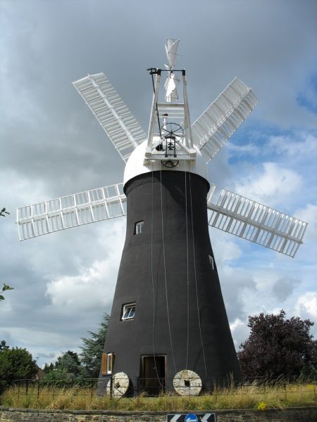 Restored Holgate Windmill in York, England, with a pair of millstones at entrance.