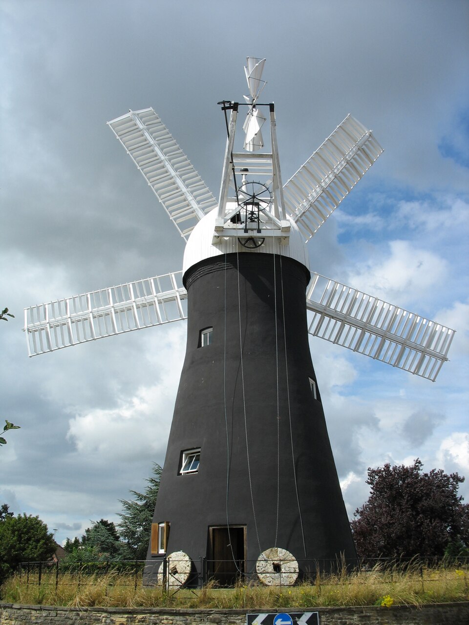 Restored Holgate Windmill in York, England, with a pair of millstones at entrance.