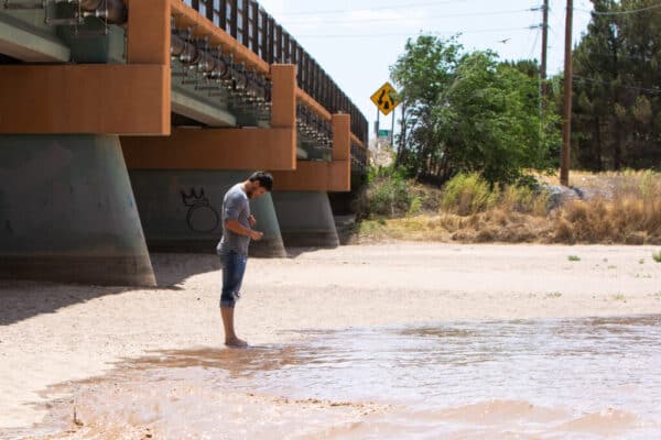 Water from Caballo Reservoir reaches the feet of a patient celebrant of the annual lower Rio Grande irrigation release