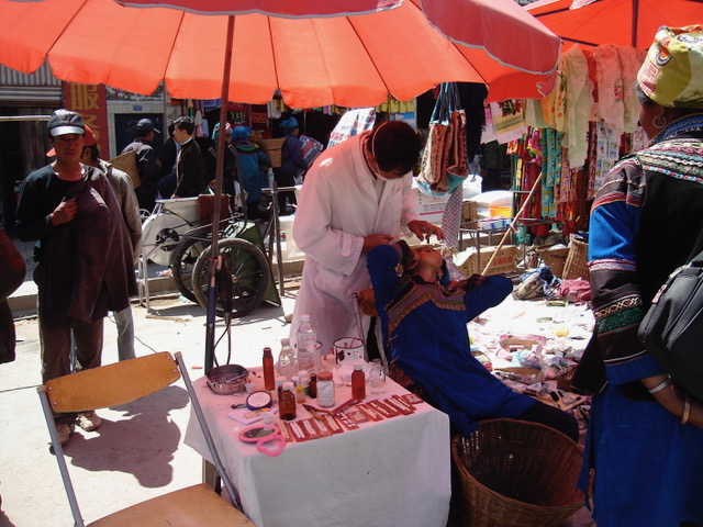 Woman getting a tooth pulled at the market.