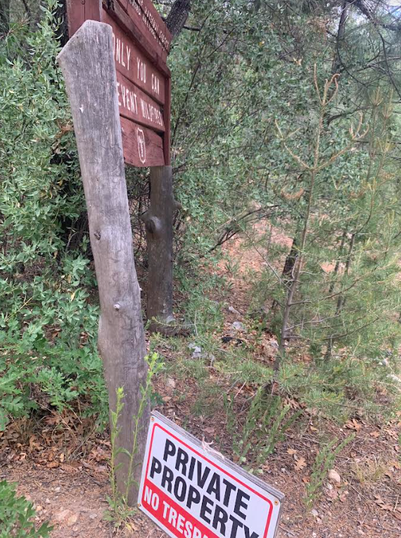 No trespassing sign at foot of National Forest sign