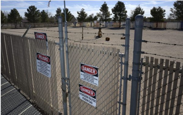 Chain link fence with warning signs of danger and the presence of poisonous gas.