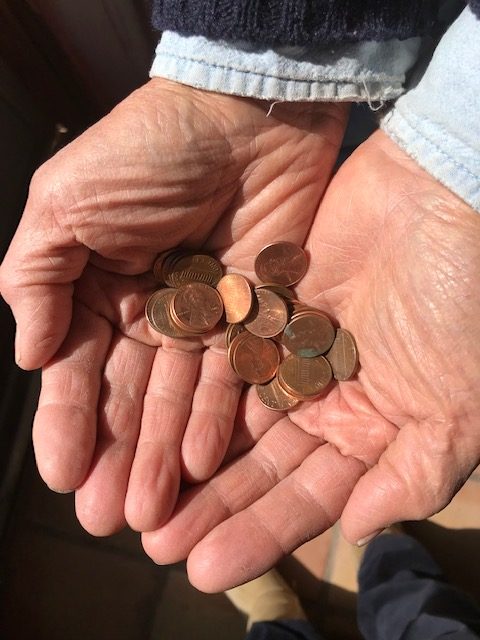 Cupped hands holding some pennies.