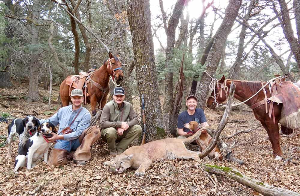 Three men with three hunting dogs from the Whitaker Brothers Hunting website